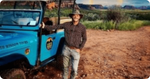 A man standing next to a blue truck.
