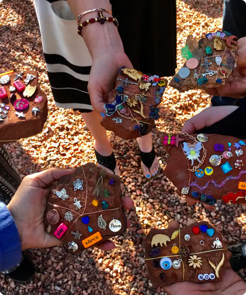 A group of people holding up chocolate bars covered in jewels.