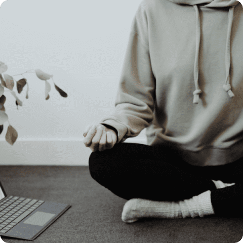 A person sitting on the ground with their feet crossed.