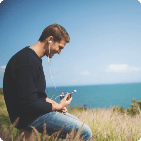 A man sitting on the grass with headphones