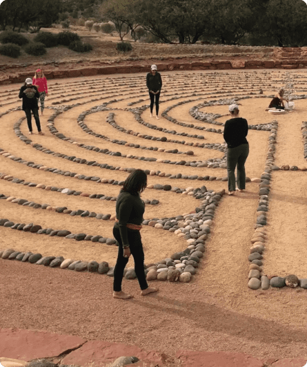 A group of people standing around in the sand.