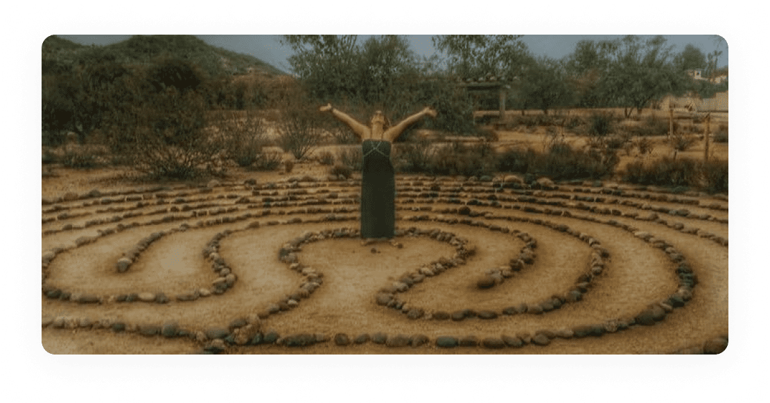 A woman standing in the middle of an outdoor labyrinth.