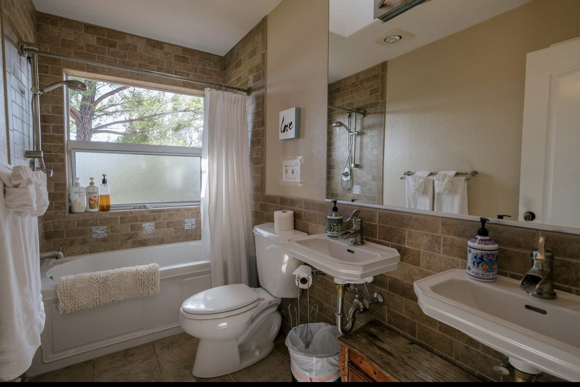 A bathroom with a toilet, sink and bathtub.